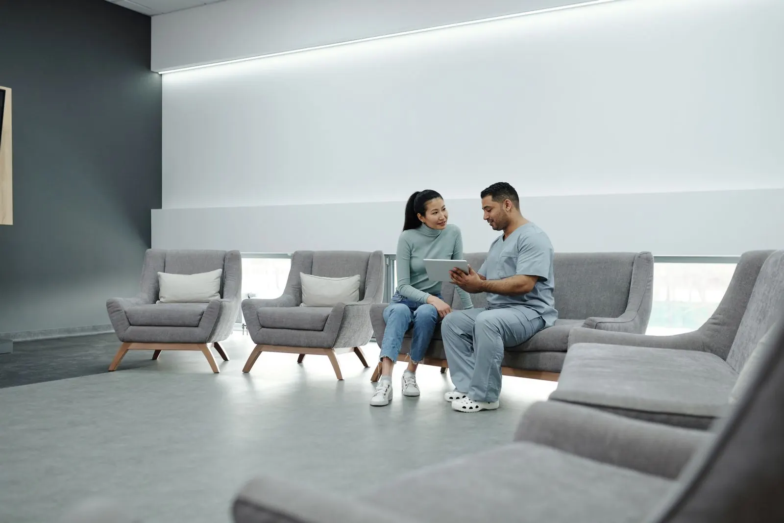 Doctor consulting with a patient while reviewing information on a tablet