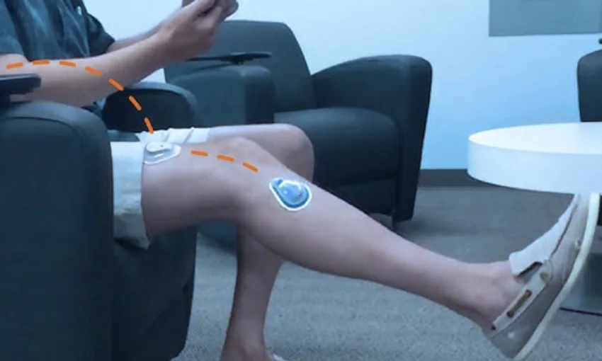Patient performing a seated knee movement while wearing TracPatch sensors